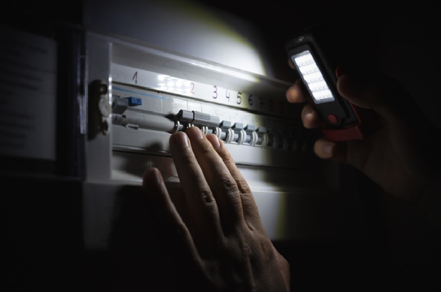 Checking a breaker panel with a work light during a power outage