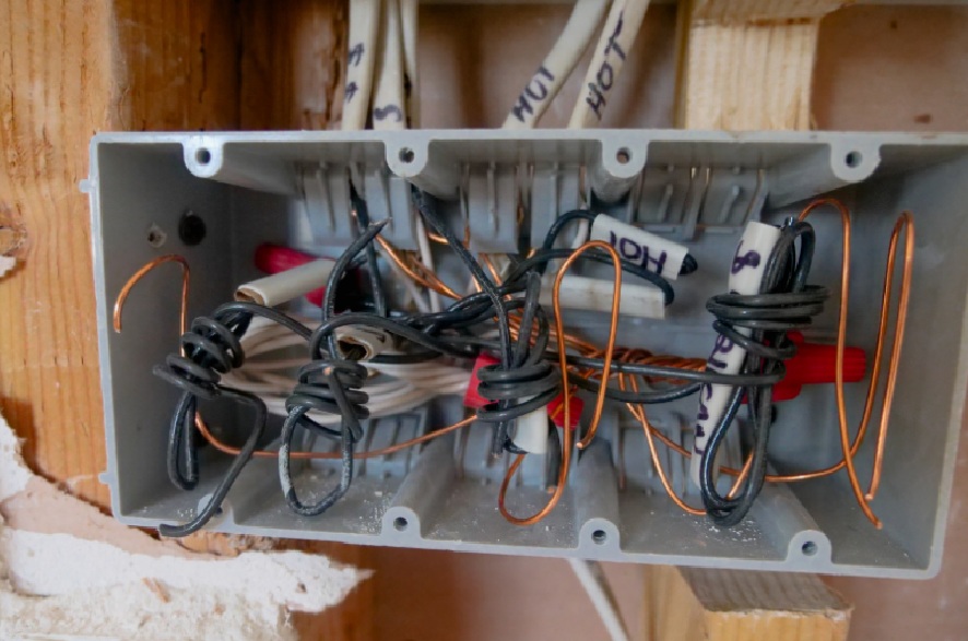 Tangled, labeled electrical wiring inside an open junction box