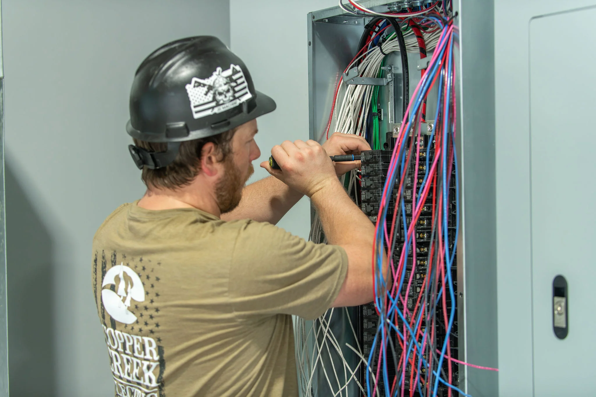 Copper Creek Electric technician wiring a commercial electrical panel