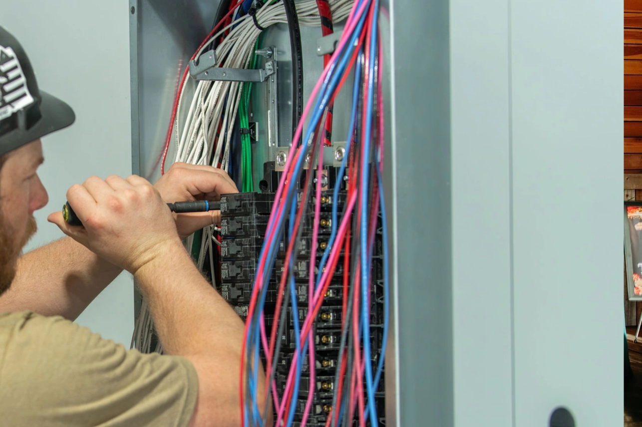 Copper Creek Electric, Goodlettsville - electrician adjusting circuit breakers in a home electrical panel